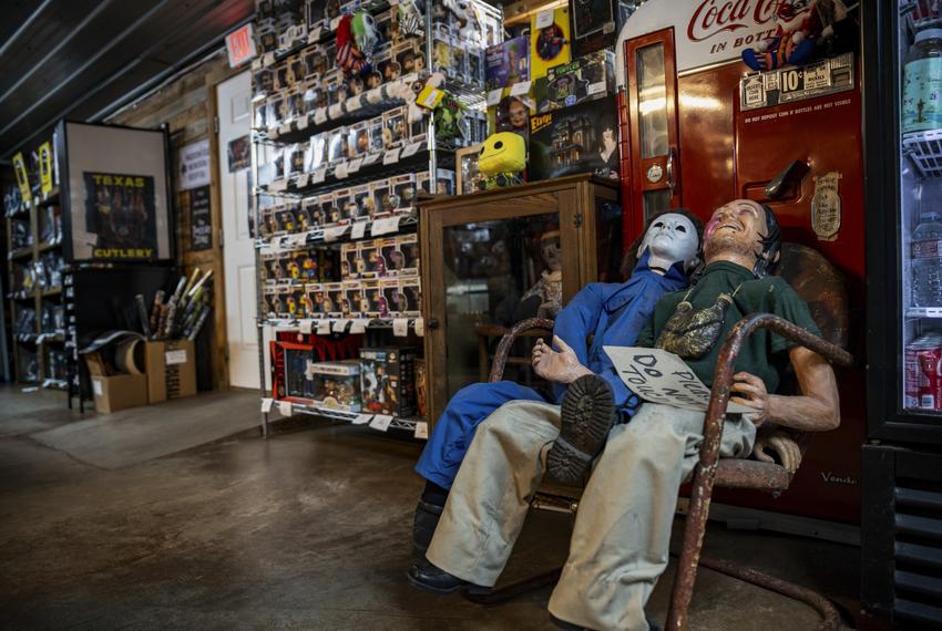 Two life-size horror movie dummies sit in front of a movie prop drink vending machine at We Slaughter BBQ on Oct. 27, 2023 in Bastrop. The roadside rest stop and tourist attraction, now restored, is one of several Central Texas locations where the 1974 film Texas Chainsaw Massacre was filmed.    